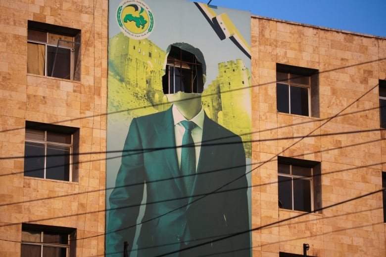 A view shows a damaged poster of Syria's President Bashar al-Assad.