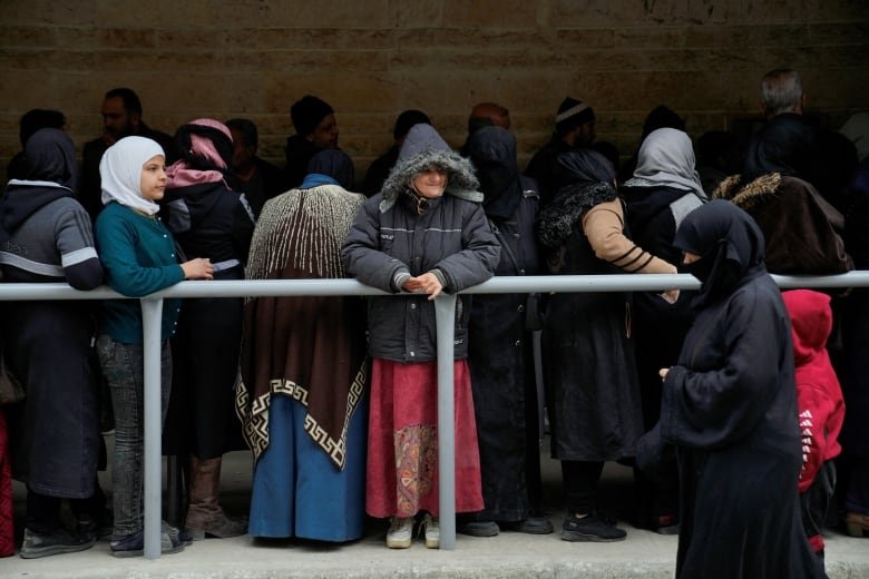 People queue to buy bread, after rebels took the main northern city of Aleppo and have since pushed south from their enclave in northwest of the country, in Aleppo, Syria, December 4, 2024. 