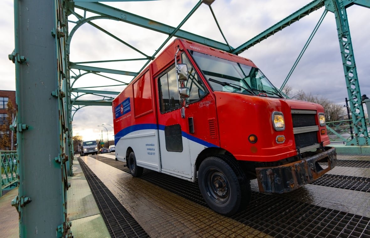 A Canada Post truck is seen on a road in Montreal on Tuesday, Dec.17, 2024. Canada Post is resuming operations after a month-long strike by more than 55,000 postal workers left letters and parcels in limbo.THE CANADIAN PRESS/Christinne Muschi