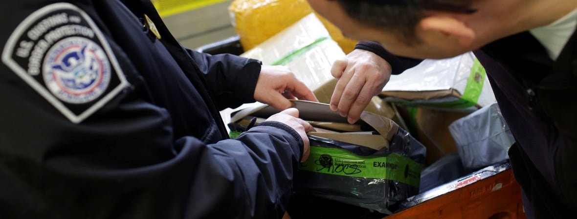 U.S. Customs and Border Protection officers inspect a package at the International Mail Facility at O'Hare International Airport in Chicago, Illinois, U.S. November 29, 2017. Picture taken November 29, 2017. REUTERS/Joshua Lott - RC1D083672F0