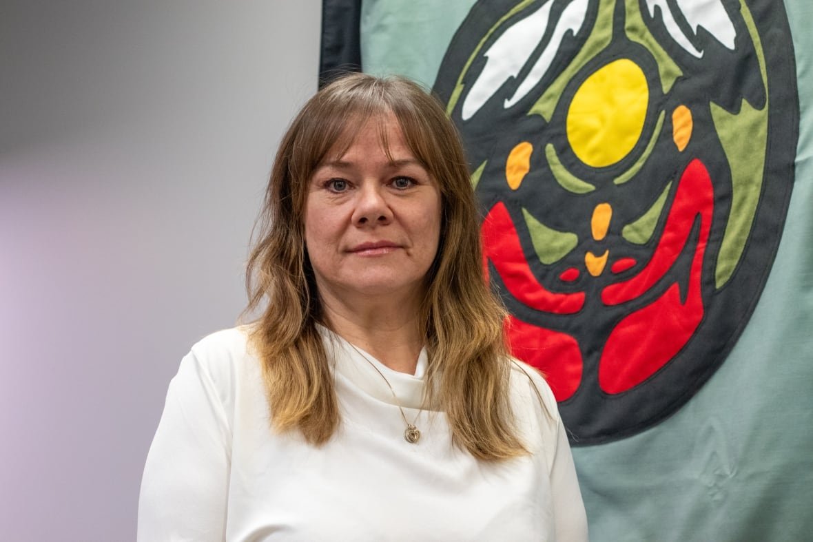 A person is seen standing in front of a blanket mural on a wall.