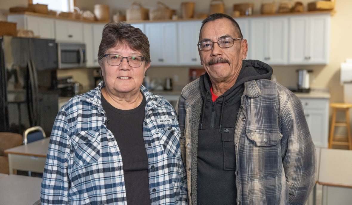 Two people stand together inside community kitchen.