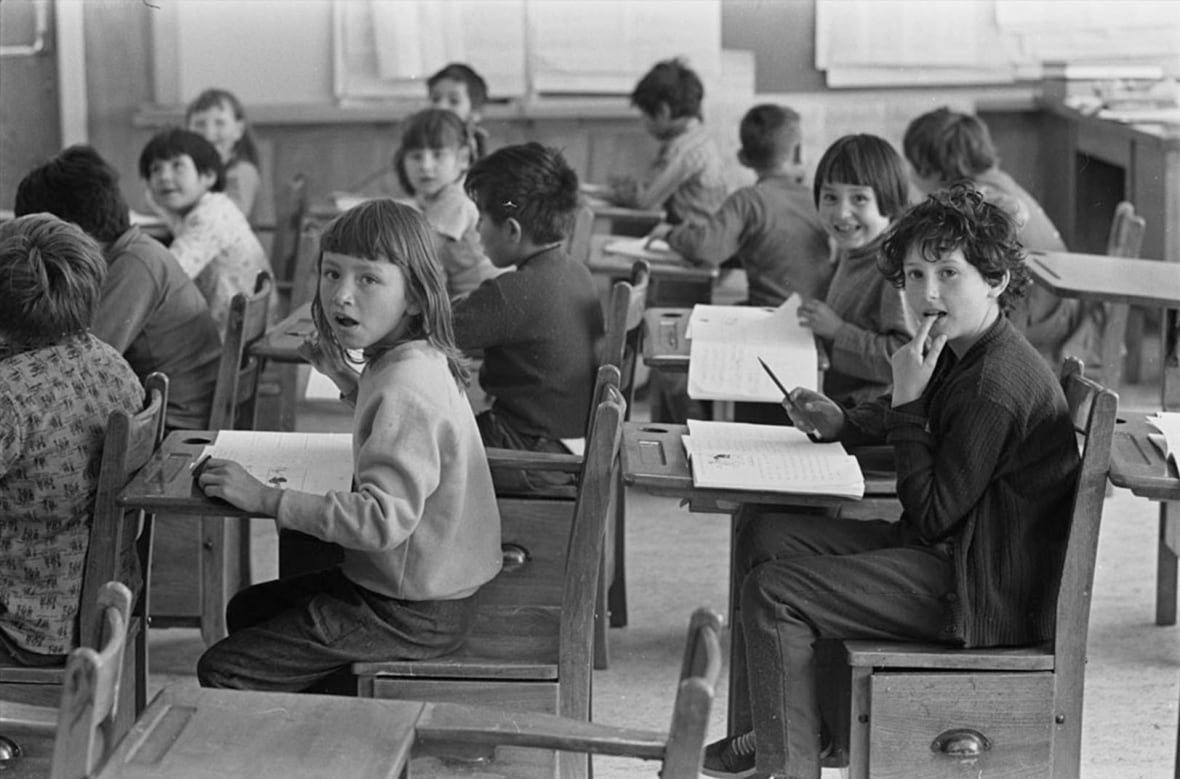 A black-and-white photo of young children in a classroom.