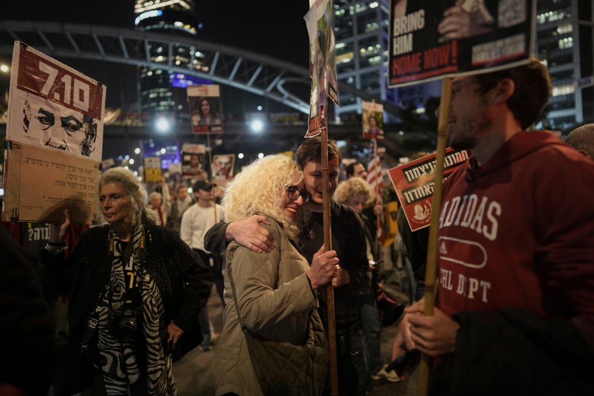 Holding placards, people react to the ceasefire announcement in Tel Aviv