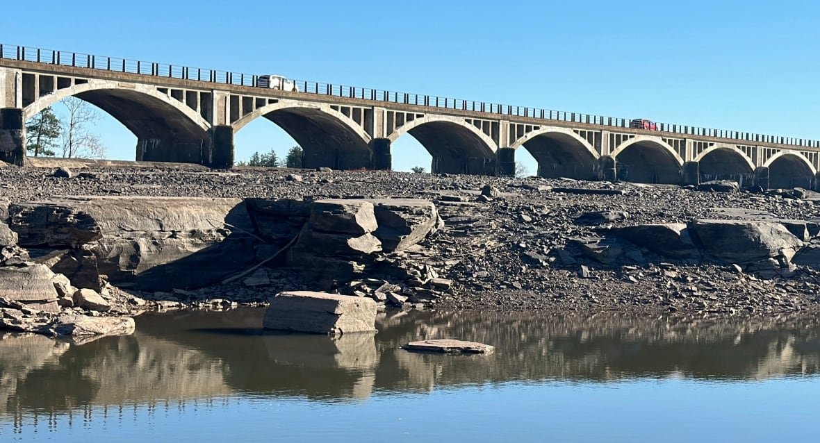 A bridge is shown with the water level significantly farther than it usually is, revealing the rock bed the bridge is sitting on. 