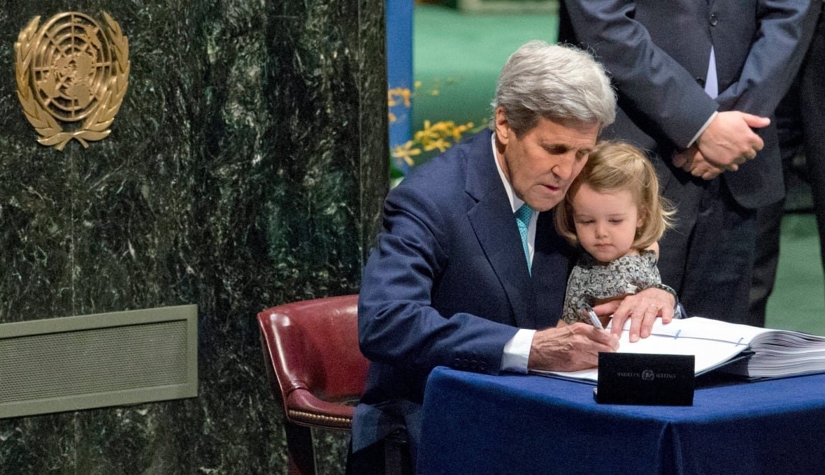 Former U.S. Secretary of State John Kerry holds his granddaughter as he signs the Paris Agreement on climate change in 2016 at UN headquarters. President Donald Trump's withdrawal from the agreement puts global climate diplomacy into a period of uncertainty.