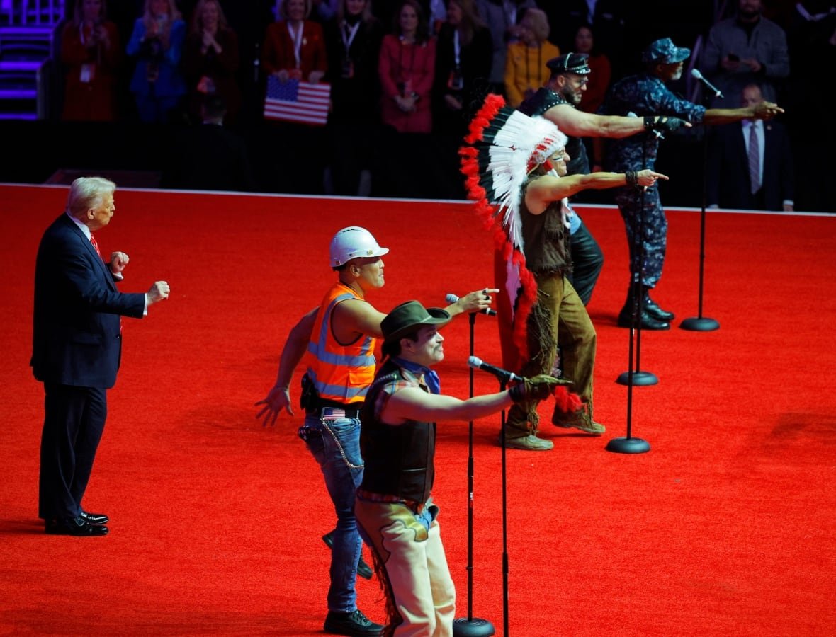 Trump on stage with people in Village People costumes